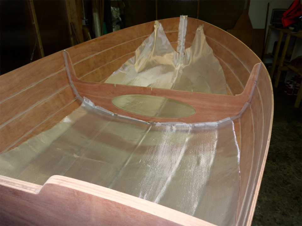 Seuls les quatre bordés de fond seront stratifiés, intérieur-extérieur. En effet, le fond est la partie du bateau qui est la plus maltraitée, soit par les contacts avec le sable et les cailloux pour l'extérieur, soit parce que l'on marche dessus pour l'intérieur. J'ai coupé deux pièces de tissu de verre pour l'avant et l'arrière. La pièce avant est complétée par une bande qui couvre le joint-congé du haut de l'étrave au brion inclus. 