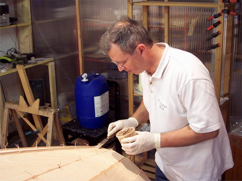 Premier collage : Gilles est ici occupé à racler l'excédent d'époxy chargée que nous avons déposée dans tous les joints à la seringue, puis lissée à la cuiller, selon une technique ancestrale que j'ai découverte en 2008. 