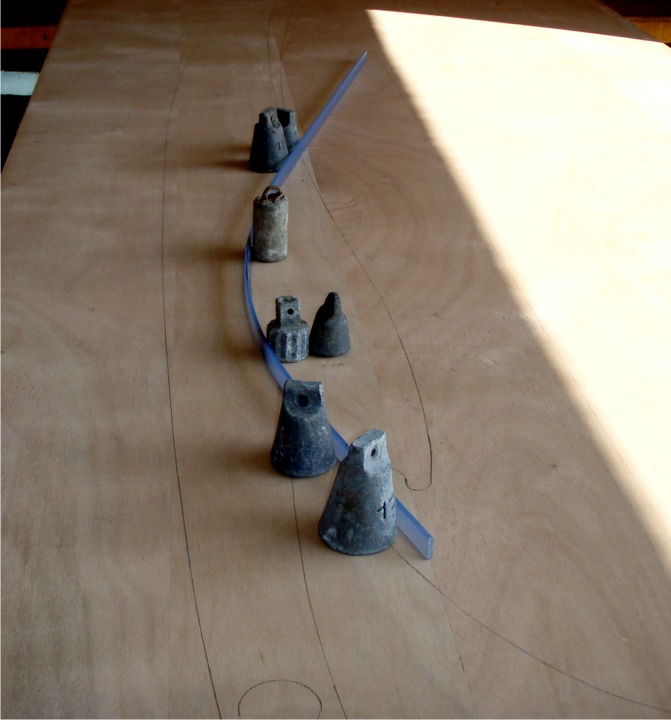 Les six photos que voici me sont envoyées par Charly, qui construit un Matunuck sur plans à Douarnenez. Voilà 10 jours, nous avons vu le début du tracé des pièces et de la découpe. Voici la suite du tracé, avec de gros plombs de pêche pour tenir la latte cintrée sur le tracé à réaliser. 