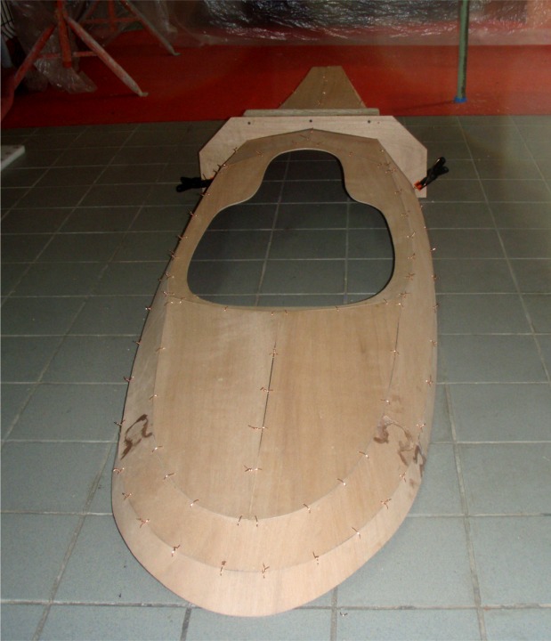 Charly continue de construire son Matunuck Surf Kayak sur plans. Voici le pontage suturé, vu de l'arrière. Les taches d'époxy de part et d'autre de la poupe sont les collages des joints-puzzle. 