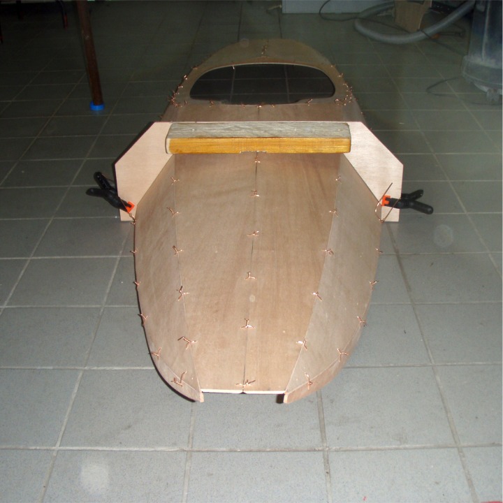 Et vu de face. Le trou de la proue sera fermé par une pièce d'étrave sculptée en bois. Le gabarit, ou "couple femelle" (je n'oserais pas si cavalièrement parler de lesbiennes !) définit les quatre angles entre les panneaux de la partie avant du pontage. 