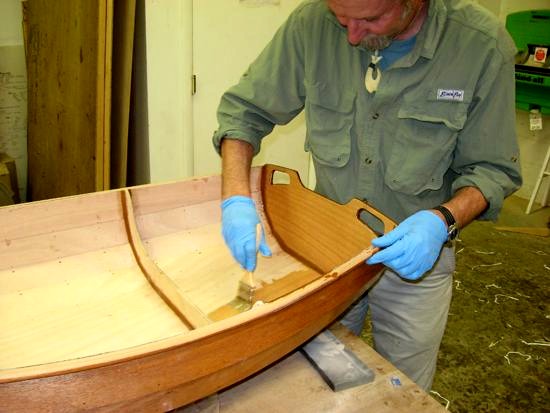 Mark passe la couche d'impr&eacute;gnation &agrave; l'&eacute;poxy "claire" sur la surface int&eacute;rieure de la coque. 