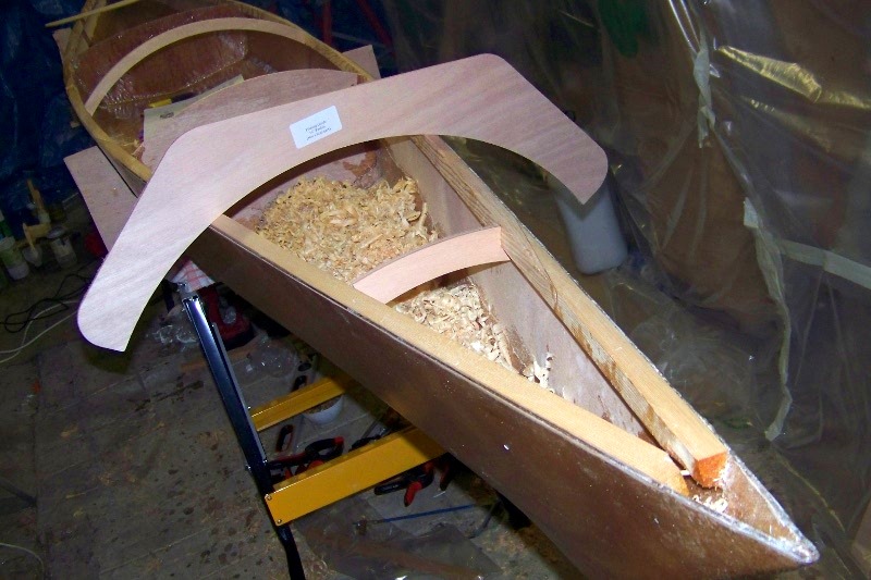 Beno&icirc;t a retourn&eacute; sa coque, fix&eacute; les deux barrots qui supportent le pontage avec les deux cloisons, et il a rabot&eacute; le dessus des serres pour suivre le "bouge" du pont, gr&acirc;ce aux deux guides de courbure fournis avec le kit, un pour le pontage avant (visible ici) et un pour l'arri&egrave;re, nettement plus plat. 