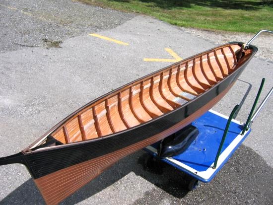 Voilà la coque sur son chariot de mise à l'eau. La coque est construite classiquement en petites lattes de bois sur membrures sciées en contreplaqué. Elle est lestée dans les fonds et pèse 20 kg. L'extérieur est stratifié verre-époxy et les bords des plaques de cuivre de revètement sont simulés en relief par de très fines bandes d'adhésif.