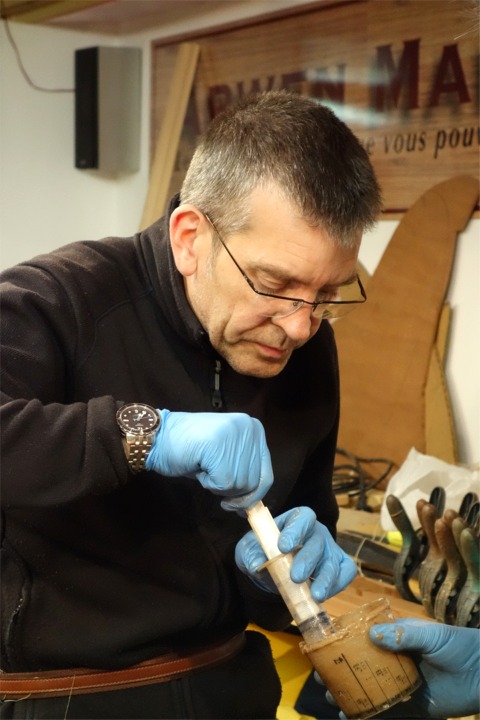 Jean aspire de l'&eacute;poxy charg&eacute;e dans sa seringue pour proc&eacute;der au collage. 