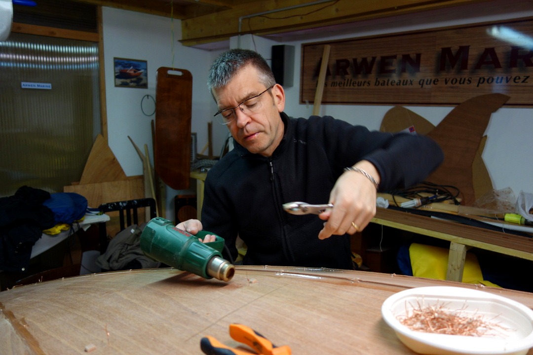 Nous retournons de nouveau la coque pour extraire les sutures &agrave; la pince, et le d&eacute;capeur thermique sert &agrave; chauffer celles qui sont dans la colle, notamment toutes celles de la marotte, du tableau et des membrures avant et arri&egrave;re. Certaines de ces sutures, trop bien coll&eacute;es ne "viendront" pas, et nous les laisserons dans la coque, en les coupant au ras de la surface. 