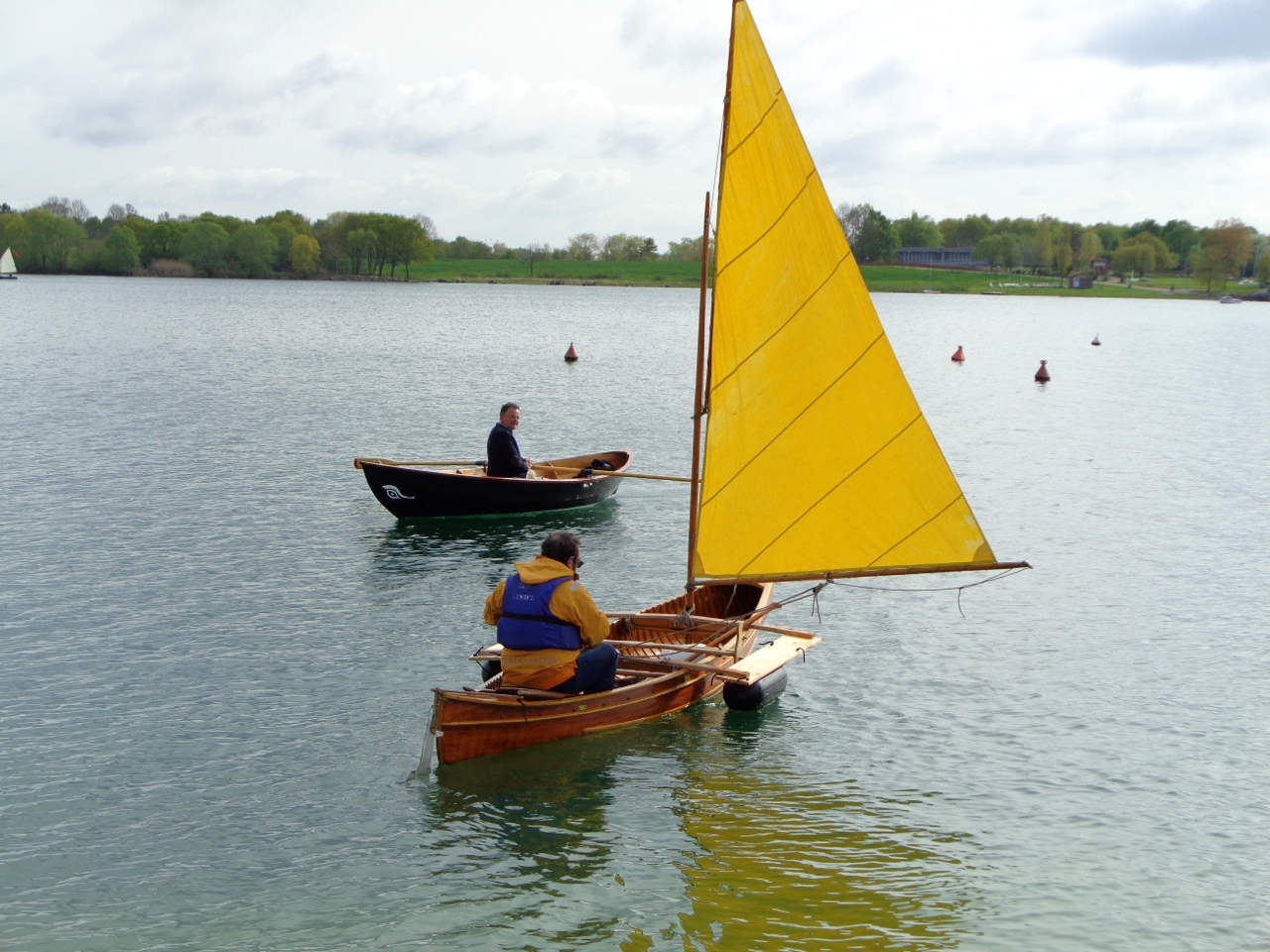 Au premier plan, c'est "Wapiti", le cano&euml; &agrave; voile r&eacute;cemment am&eacute;nag&eacute; par Guy, qui vient de Strasbourg pour faire sa premi&egrave;re sortie. A c&ocirc;t&eacute;, c'est Dominique &agrave; bord de "Na&iuml;ma". Il a cass&eacute; son pied de m&acirc;t dans la brise de la veille, et est donc condamn&eacute; &agrave; ramer.