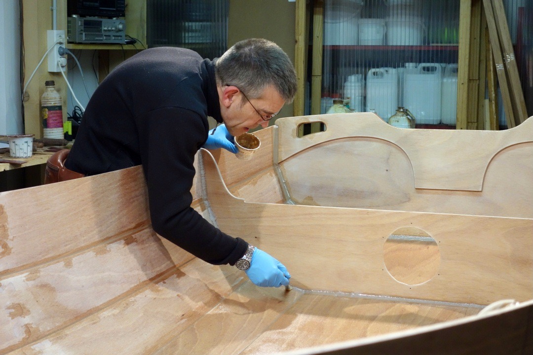 Jean utilise le pinceau pour remettre en place les bords du tissu apr&egrave;s la coupe, qui d&eacute;place un peu les fibres et cr&eacute;e des bulles en p&eacute;riph&eacute;rie. 