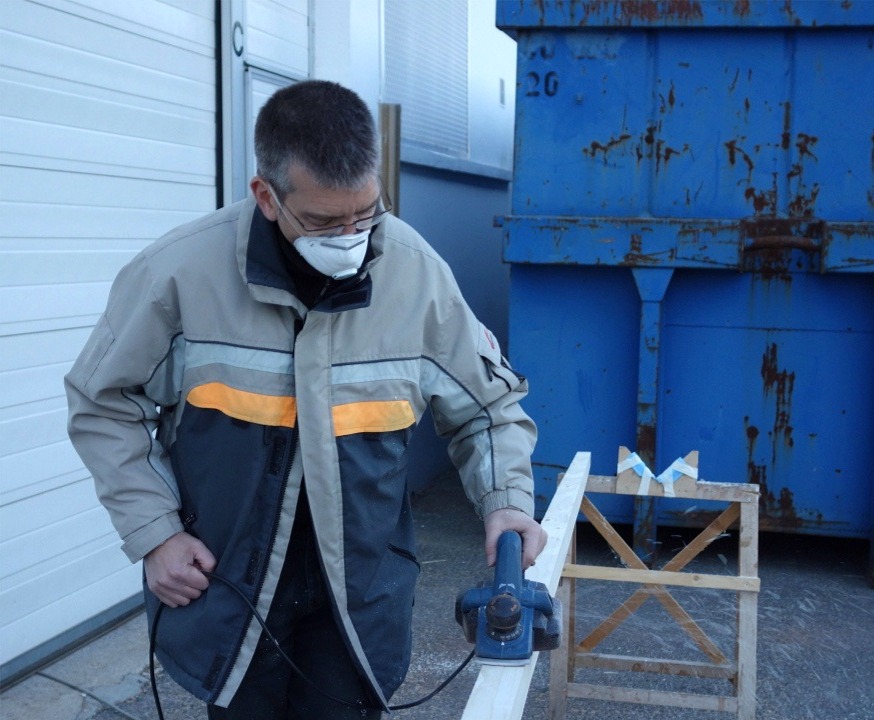 Apr&egrave;s d&eacute;coupage &agrave; la scie des 4 faces, Jean utilise le rabot pour finir de les "dresser". Le m&acirc;t est &agrave; plat pour ce travail, mais il sera ensuite pos&eacute; sur les supports &agrave; 45&deg; viss&eacute;s sur les tr&eacute;teaux (on en voit un derri&egrave;re Jean). 