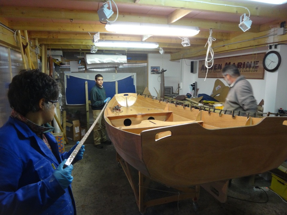 Le liston tribord est en place et Cyrille et Marie-Pierre pr&eacute;sentent les deux lattes du liston b&acirc;bord, tandis que j'arrive pour poser la premi&egrave;re presse. 