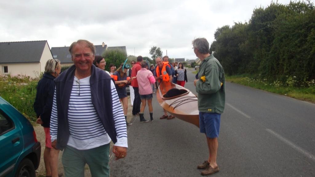 Un cortège s'organise pour porter le kayak au son du yukulele vers la grève voisine afin de procéder à son lancement. 