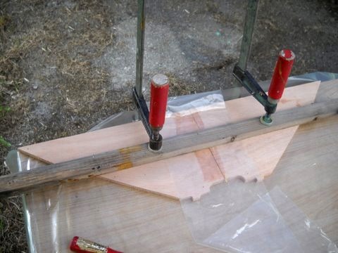 Collage des deux moitiés de la petite cloison arrière. Les petits tenons entrent dans des mortaises taillées dans la sole lors de la découpe sur la machine à commande numérique, ce qui facilite le positionnement de toutes les membrures. L'ouverture centrale est un anguiller, car il n'y a pas de compartiments étanches sur la version "aviron", la flottabilité est assurée par des blocs de mousse (115 litres) sous les bancs. 