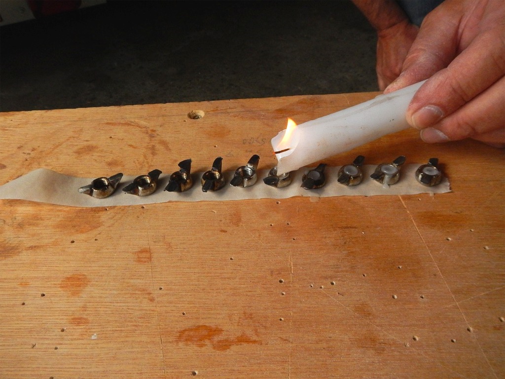 Avant de coller les écrous à oreilles, nous les bouchons à la cire grâce à cette bougie, afin d'éviter que l'époxy vienne coller les filetages. Nous nettoierons leur surface extérieure des coulures pour eviter le même effet sur l'extérieur... Et à cause de ces problèmes d'écrous noyés, nous avons donc perdu beaucoup de temps sur cette première journée et fait peu d'images : c'est ce qui arrive quand on essuie les plâtres, nous nous rattraperons demain ! Dans le futur, je pense remplacer ces inserts ou écrous à oreilles tout simplement par des écrous hexagonaux en inox A4. Le collage à l'époxy les tiendra bien suffisamment pour les empêcher de tourner, car l'effort sera en tractoin vers le fond de leur trou dans le doubleur et vers la cloison "pleine" derrière. 