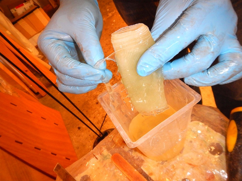 Lorsque nous sommes satisfaits de la quantité et du lissage de l'époxy chargée tout le long du joint, nous faisons tremper dans l'époxy "claire" des pièces de bande de fibre de verre (découpées préalablement à la longueur correspondant à chaque section de joint) afin de les saturer préalablement à leur application, car il sera difficile (!) d'aller les saturer une fois en place. 