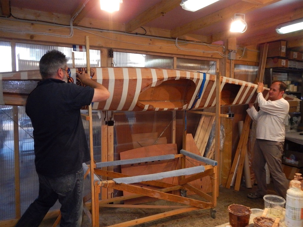 Une fois toutes les pièces de bande en place, nous tournons le kayak afin de réaliser le joint bâbord, mais nous n'avons pas fait de photos de la suite, qui présente une difficulté supplémentaire : l'époxy claire de saturation des bandes est un peu en excédent quand on sort les bandes trempées du pot où elles ont trempé, et elle s'écoule ensuite un peu partout à l'intérieur, et notamment sur le rebord des trappes et du cockpit : gare à vos cheveux ! Nous avons sauvé les notres grâce à un shampoing immédiat au vinaigre pur ! 