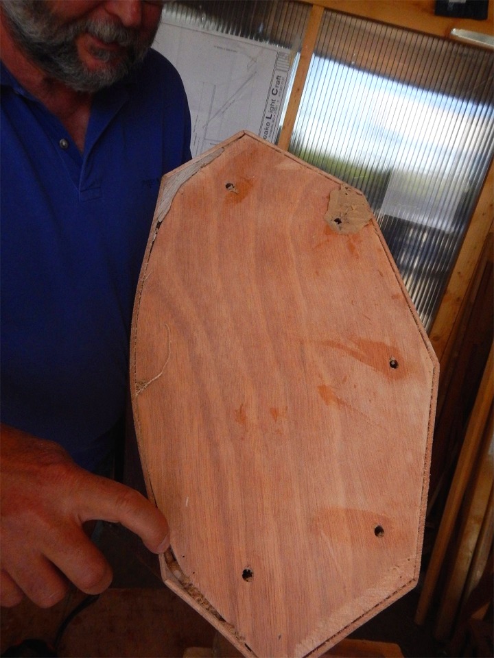 J'ai la partie avant en main et je pointe du doigt l'endroit où nous allons devoir compléter le joint, dans l'angle haut bâbord. On voit clairement que le pontage est assez éloigné de son cintrage théorique, ce qui rend ces comblements nécessaires. 