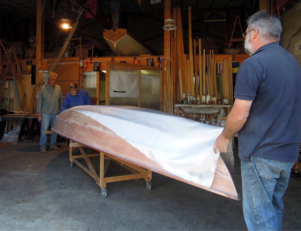 Nous drapons la pi&egrave;ce de tissu de verre sur la surface &agrave; stratifier : comme pour l'int&eacute;rieur, cette tratification ne concerne que la sole et les deux bord&eacute;s 1, avec une bande de renfort sur l'&eacute;trave et une autre sur l'&eacute;tambot. 