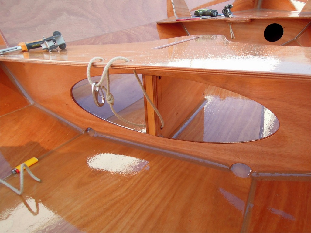 Le capelage de la poulie basse du palan d'&eacute;coute passe &agrave; travers le bas du puits de d&eacute;rive et &agrave; travers l'arri&egrave;re du si&egrave;ge milieu. Un mousqueton permet de le lib&eacute;rer instantan&eacute;ment lorsque l'on d&eacute;gr&eacute;e la voile. 