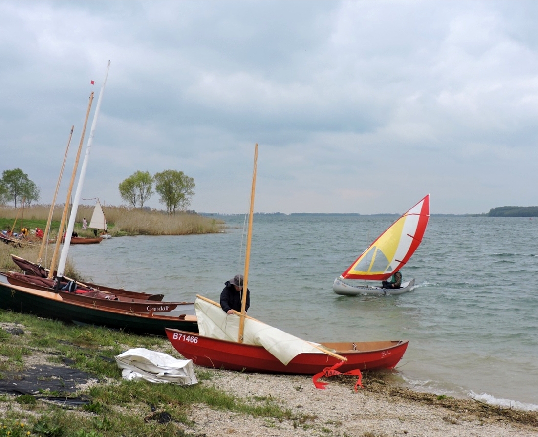 "Eolo" arrive pleine balle au grand-largue, tandis que Benoit prépare la voile de son Skerry "Bahari". 