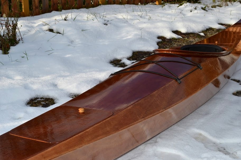 Pierre a monté le système de fermeture "invisible" pour ses trappes : le bouton en bois clair permet d'entrebailler la trappe pour libérer les tendeurs qui la tiennent fermée. Les deux tendeurs de chaque trappe sont ancrés sur des blocs de bois collés sur l'intérieur des panneaux latéraux sous la trappe. Superbe. 