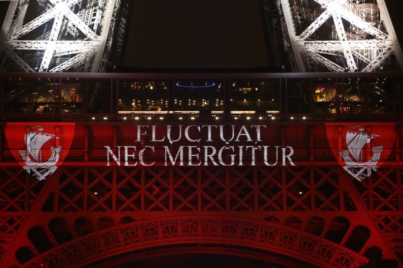 Et au d&eacute;but de cette nuit se produisent les attentats de Paris. La devise de la ville devient un slogan anti terroriste : Fluctuat nec mergitur : battue par les flots mais sans couler... La voici projet&eacute;e sur la Tour Eifel le 16 novembre, dans le haut du rouge des trois couleurs de notre drapeau national (seul le blanc n'appartenait pas aux couleurs de Paris, c'&eacute;tait la couleur du roi). Photo : Ludovic Marin/AFP. 
