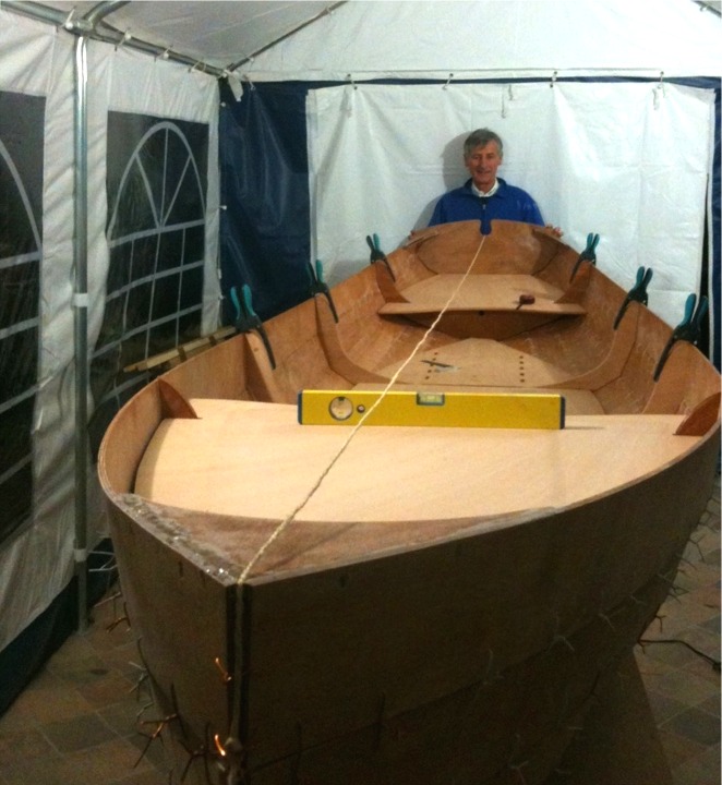 Les éléments de structure sont en place : des positions théoriques sont indiquées pour les éléments transversaux (les deux membrures centrales et les deux cloisons avant et arrière), mais ces positions doivent être validées par le positionnement des éléments horizontaux (les dessus des caissons et les planchers). Le niveau à bulle sert à vérifier que la coque n'est pas voilée, et le fil matérialise la ligne médiane de la coque et aide à la vérification. 