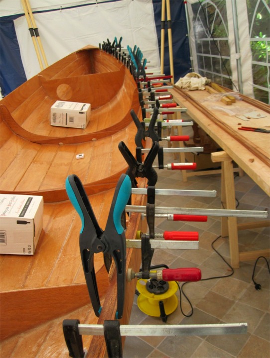 Et voici six images que nous envoie Herv&eacute;, qui prend toujours autant de plaisir &agrave; construire sa Yole de Chester (et le fait savoir !) Sur cette premi&egrave;re image, Herv&eacute; colle l'un des plis des listons sur l'int&eacute;rieur du bord&eacute;, le transformant ainsi habilement en serre ! Notez le ballast liquide qui sert &agrave; &eacute;viter que le poids des presses sur un seul bord ne fasse chavirer et tomber le bateau des tr&eacute;teaux : des caisses de Saint-Emilion, s'il vous plait ! 