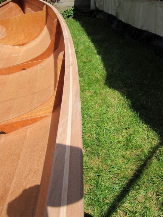 Hervé m'envoie une photo de sa Yole de Chester : il est en train de finir de poncer le haut du carreau. Au lieu de coller les deux épaisseurs du liston sur l'extérieur du bordé, il en a collé un pli sur l'intérieur, prenant ainsi le bordé en sandwich entre un liston et une serre. 