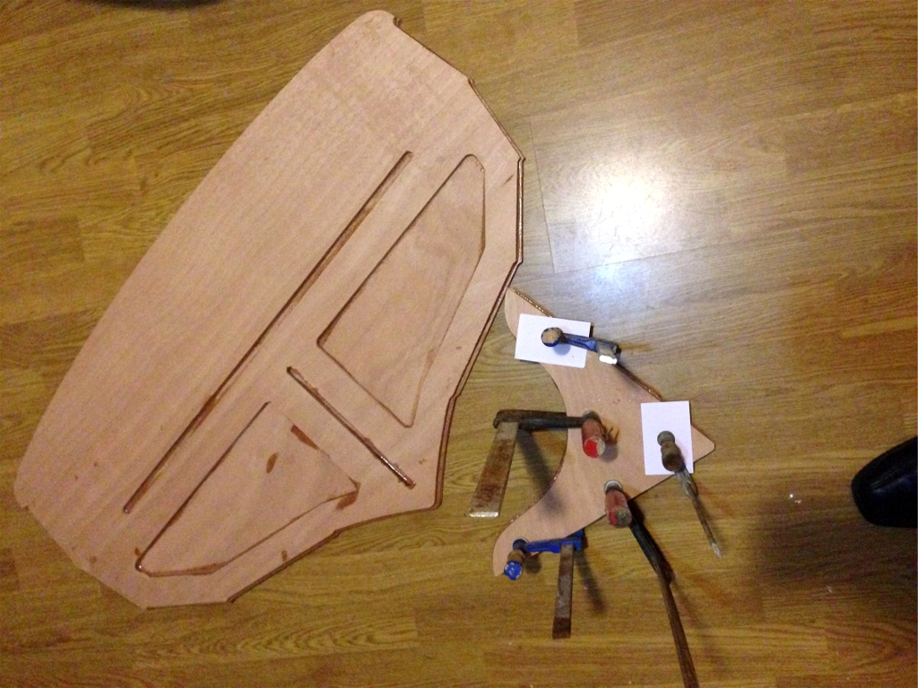 Le tableau est pr&ecirc;t &agrave; l'emploi. La rainure horizontale recevra, le moment venu, l'extr&eacute;mit&eacute; des deux demi-pontages arri&egrave;re. La petit rainure verticale recevra l'&eacute;tambot. A droite, collage des deux &eacute;paisseurs de la guirlande (notez qu'Herv&eacute; ne craint pas les coulures d'&eacute;poxy sur son parquet !) 