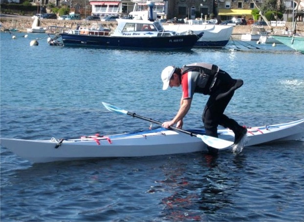 Christophe monte &agrave; bord, on distingue la "jupe" accroch&eacute;e &agrave; sa taille, pr&ecirc;te &agrave; agraffer sur l'hiloire. Son r&ocirc;le est d'occulter l'ouverture du cockpit afin de le rendre &eacute;tanche aux embruns. 