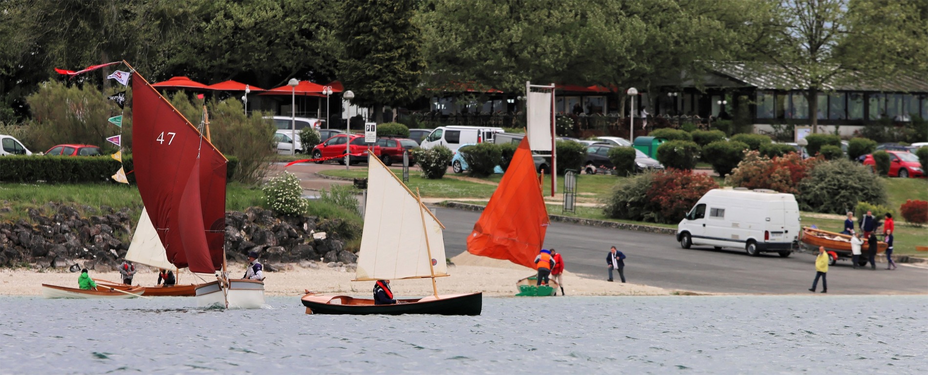 Tandis que le joli Minahouet Njord s'apprête à aller à l'eau, à droite, on envoie les voiles sur le Biraou Carpe Diem, au centre, et Atipik, Thema, Prise de Ris'k et la Yole de Chester naviguent. 