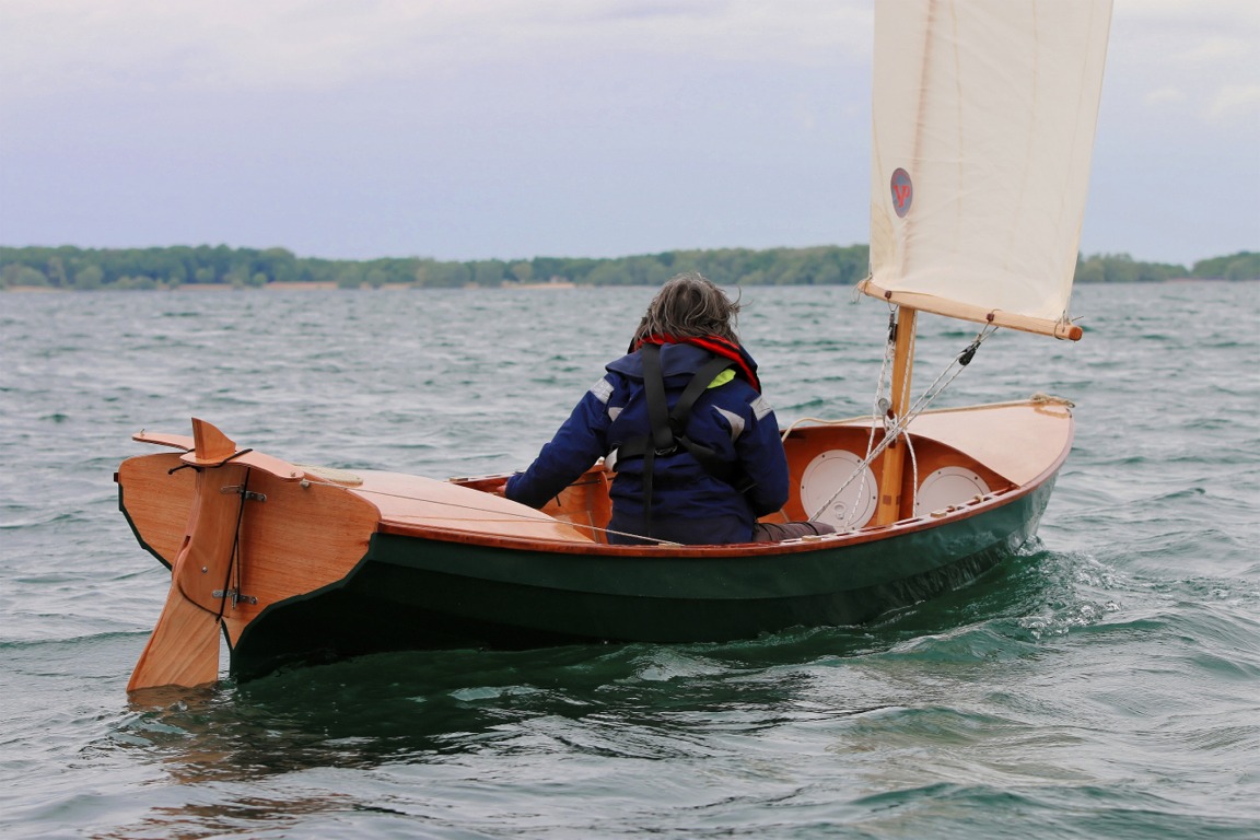 Katia est assise sur le tabouret de nage face à la route et barre à l'aide de la drosse bâbord. Pierre a connecté les deux drosses sur des tendeurs, de sorte que le bateau va tout droit si l'on ne touche à rien. 