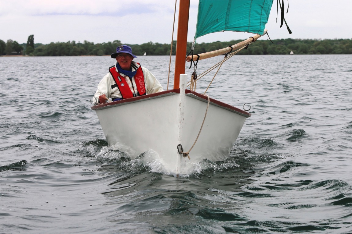 Le Goat Island Skiff Takka de face. Son architecte prescrit du contreplaqué okoumé de 6 mm pour l'ensemble de sa coque, sans stratification complète : seules les arètes des bouchains sont normalement convertes d'une bande de fibre, de même que les joints-congés. 