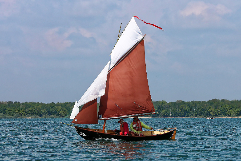 Gros plan sur le nouveau gréement de côtre à flèche du Skerry Naïma : Dominique avait depuis longtemps ajouté un foc de Doryplume à sa misaine, mais cette année il complète avec un foc volant (ou, pour être plus précis, un foc qui transforme celui qu'il avait déjà en trinquette) et un flèche gréé sur un mâterau fixé en haut du mât. le mâtereau, la vergue du flèche et le bout-dehors sont tous en bambou. 