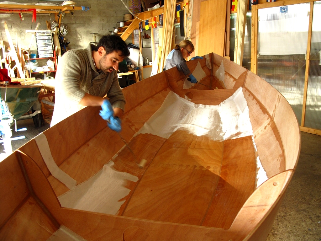 Nous utilisons des rouleaux pour d&eacute;poser la r&eacute;sine &eacute;poxy sur le tissu de verre et la faire p&eacute;n&eacute;trer dans le tissu jusqu'&agrave; ce qu'il soit satur&eacute;, ce qui le rend transparent (rappelez-vous : c'est du verre !) La difficult&eacute; est de ne pas bouger le tissu en le tirant avec le rouleau, ce qui cr&eacute;erait des bulles et toutes sortes d'imperfections. 