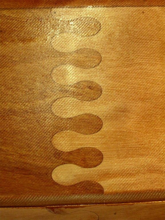 Ce gros plan sur la stratification recouvrant le joint-puzzle qui unit les deux moiti&eacute;s du bord&eacute; 1 est plein d'informations. Les feuilles de contreplaqu&eacute; standard font 2.50 m de longueur et le Skerry est construit pour tenir dans deux longueurs de contreplaqu&eacute; : il faut donc joindre bout &agrave; bout les deux feuilles de contreplaqu&eacute;. Par le pass&eacute; on le faisait &agrave; l'aide de "scarfs" (en fran&ccedil;ais "enture" ou joint en &eacute;cart), mais avec la d&eacute;coupe num&eacute;rique, on fait ce qu'on veut. On voit en haut de l'image je joint avec la sole et en bas celui avec le bord&eacute; 2. 