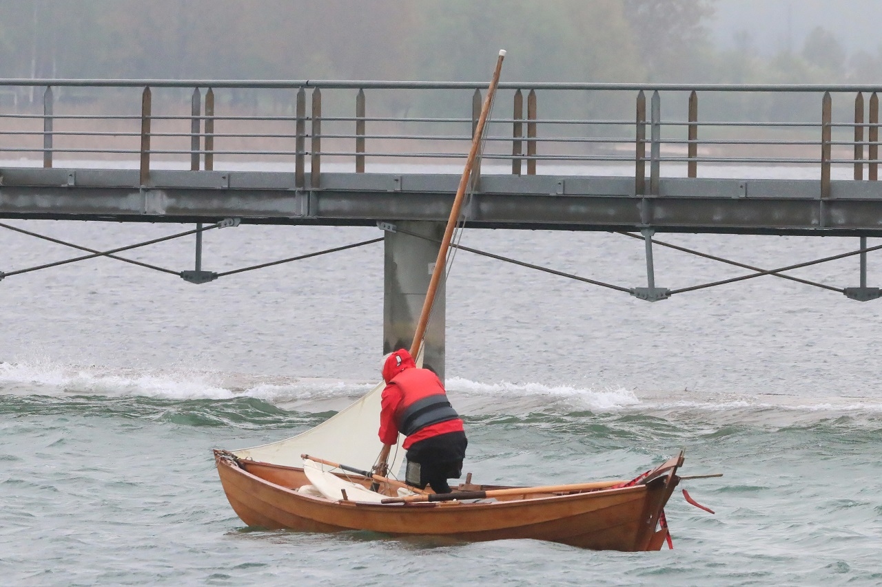 Du coup, le vent rabat Bernard sur la passerelle (cycles et pi&eacute;tons exclusivement) toute proche, et qui relie Giffaumont &agrave; Champaubert. Ses pylones sont pris dans la digue qui s&eacute;pare le lac principal d'une petite retenue (on voit les vagues qui d&eacute;ferlent sur la digue submersible). Bernard a vu le danger et s'affaire &agrave; d&eacute;mater afin de passer sous la passerelle sans casser son m&acirc;t. 