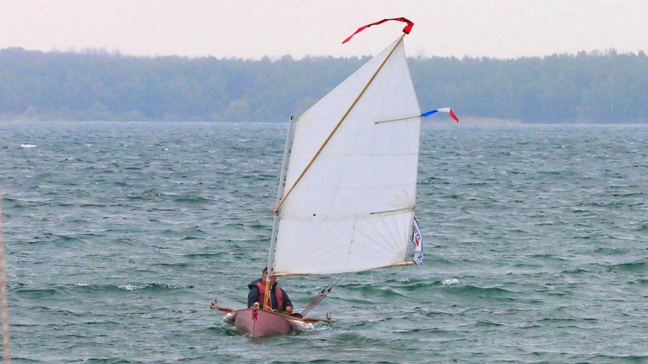 Didier nous fait une démonstration de vitesse et de maîtrise sur son "Explorameur" qui a l'air bien au point ! Admirez en particulier la belle voile qu'il a coupée et brodée cousue de ses propres mains. Notez sa coupe radiale, qui a dû bien occuper les soirées d'hiver de Didier ! 