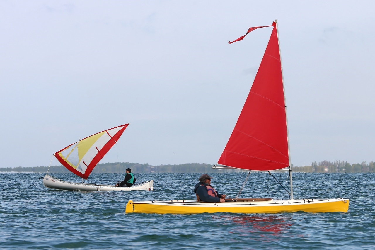 Didier (skipper de "L'Explorameur") essaie le "Merzin" construit par Francis. On aperçoit "Eolo" le canoë alu sur lequel Marco a installé une voile de planche en guise de voile latine. Ca va vite mais ça chavire aussi... 