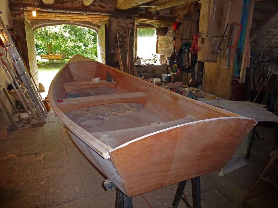 Cette vue de l'intérieur montre bien les deux bancs transversaux, chacun constituant une structure en "U" inversé très résistante. Ils participent à la rigidité de la coque et sont mis en place après la couture des panneaux de coque mais avant les joints-congés, qui figent la forme définitive de la coque. 