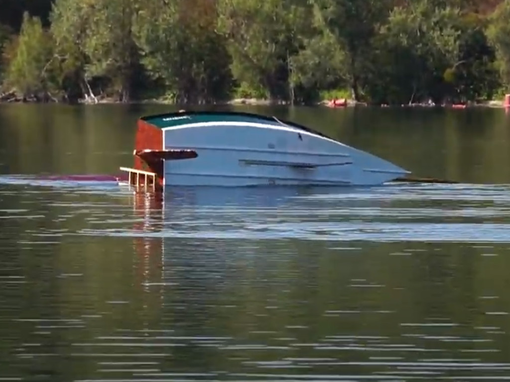 L'échelle fonctionne très bien, en ce sens que j'ai pu l'utiliser pour remonter plusieurs fois à bord après avoir redressé le bateau. Elle est munie de deux crochets en U qui s'accrochent sur le bord du tableau, à côté du gouvernail, mais ces crochets étaient trop fragiles, et nous les avons finalement cassés. J'ai finalement enfin eu une lueur d'inteligence en décidant de libérer la drisse afin que la voile reste dans l'eau lorsque l'on redresse le bateau. En effet, le poids de la voile couverte d'eau sur ses deux faces, en plus de celui du mât et des espars, rend le bateau très instable lorsqu'il est rempli d'eau (notre chère amie Karen Likid). La voile restant dans l'eau, elle agit au contraire comme un stabilisateur quand on remonte à bord par le côté opposé. Il faudra bien sûr vérifier cette hypothèse en présence de vagues. Désolé pour la mauvaise définition de l'image, c'est une capture faite sur une vidéo prise par Gérard. 