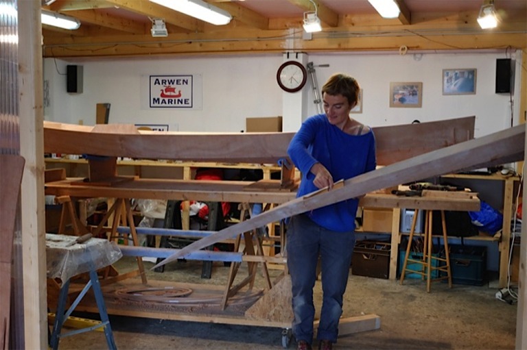 Maud saisit le pont pour le poser sur la coque afin de les solidariser l'un à l'autre pour le durcissement de l'époxy. 