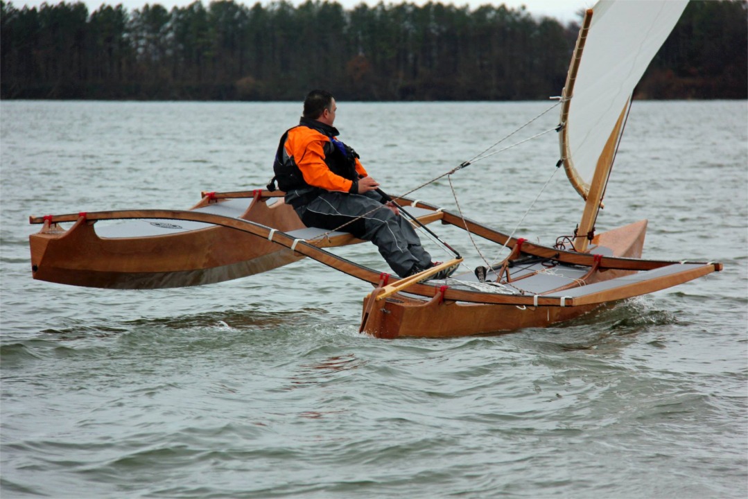Le barreur est confortablement installé sur le siège accroché aux traverses. Le stick pourrait être un tout petit peu plus long. On voit sur cette image que la bôme est très souple afin de résorber le creux de la voile dès que le vent forcit. 