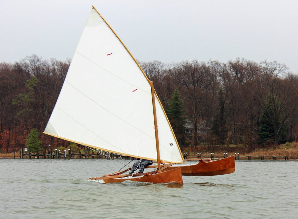 La voile latine de 15.30 m2 propulse l'Outrigger Junior à bonne allure dans le petit temps pluvieux de l'essai. On vire de bord et le flotteur se trouve au vent. Même par petit temps, le flotteur ne demande qu'à décoller, du fait du poids plume de l'ensemble. On joue de la barre et de l'écoute pour le maintenir au ras de l'eau. 