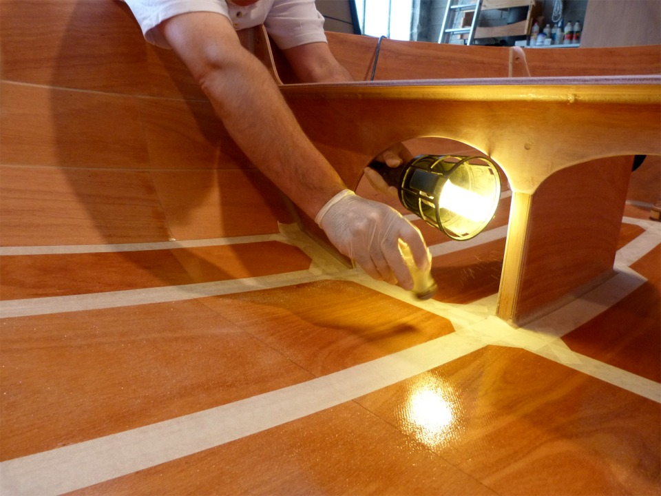 Gilles a pass&eacute; une couche d'&eacute;poxy fra&icirc;che et saupoudre les microbilles de verre &agrave; l'aide d'une simple sali&egrave;re de table. La difficult&eacute; est de r&eacute;partir les billes r&eacute;guli&egrave;rement, sans manques ni pat&eacute;s. 