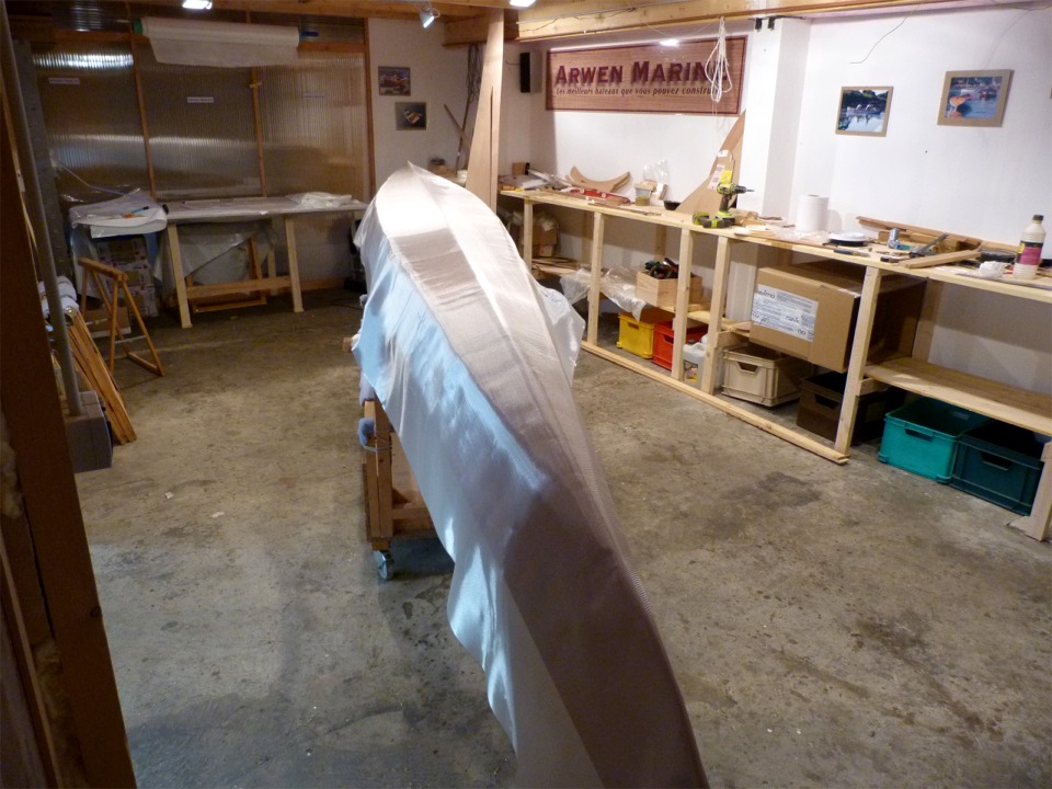 Je retourne la coque et drape le tissu de verre en vue de la stratification de sa surface ext&eacute;rieure. 