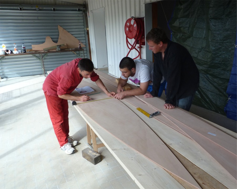 L'&eacute;quipe a coll&eacute; les joints-puzzle de la sole et des bord&eacute;s de l'un des deux Skerry : premi&egrave;re exp&eacute;rience avec l'&eacute;poxy pour tous, et ils ont fait un excellent travail. Sur cette image, on trace l'emplacement des cloisons et membrures sur la sole, en vue de la "couture" du premier bateau. 