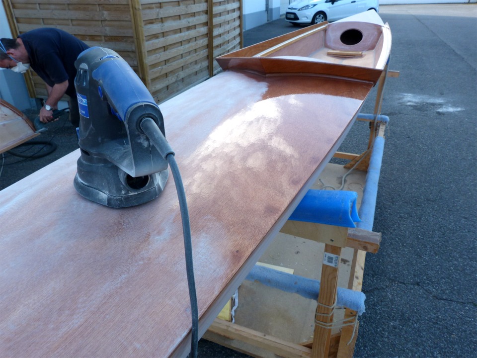 Ai-je d&eacute;j&agrave; &eacute;crit que le pon&ccedil;age est l'activit&eacute; principale dans la construction d'un bateau en contreplaqu&eacute;-&eacute;poxy ? Beno&icirc;t, occup&eacute; &agrave; poncer l'&eacute;trave du Skerry qu'il est venu r&eacute;aliser &agrave; l'atelier en "construction accompagn&eacute;e", vous le confirmera volontiers ! Je me suis pour ma part arr&ecirc;t&eacute; au milieu du pon&ccedil;age de la 3e couche d'&eacute;poxy sur le pont avant de l'Oxford Shell afin de faire cette photo. 