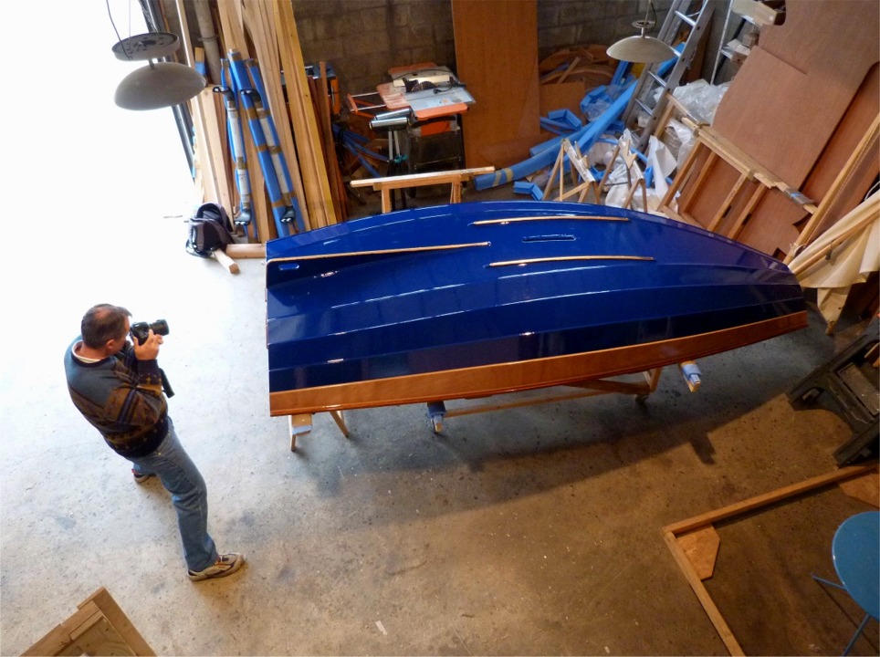 Gilles photographie notre travail de la matin&eacute;e de ce samedi : nous avons coup&eacute;, form&eacute;, perc&eacute; et frais&eacute; les trois bandes-molles en demi-ovale de laiton, que nous venons de visser en place. L'effet est spectaculaire sur la toute nouvelle peinture bleue ("Royal Blue", s'il vous plait) de la coque de son PassageMaker. 