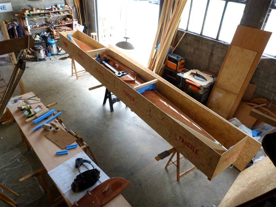 Vue a&eacute;rienne de l'Oxford Shell dans sa caisse : il reste 7.5 cm d'espace &agrave; la proue et &agrave; la poupe, que nous avons ult&eacute;rieurement amarr&eacute;es &agrave; la caisse afin d'&eacute;liminer les risques de d&eacute;placement en longueur, car je ne me fie pas aux petits bouts de mousse bleue pour amortir les chocs &eacute;ventuels sur la pointe de l'&eacute;trave ou de l'&eacute;tambot. 